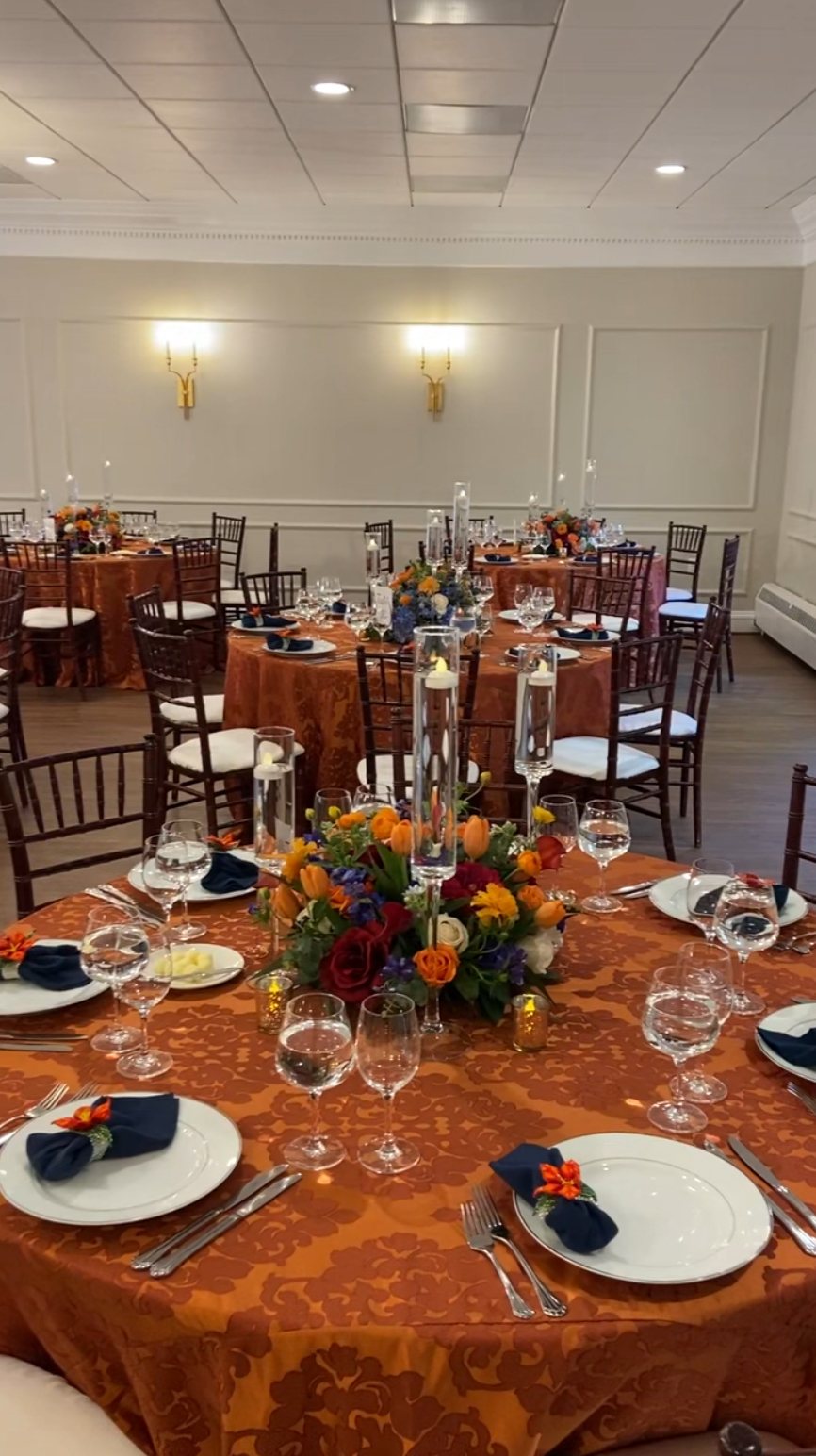 Ballroom set with round banquet tables beneath the chandeliers