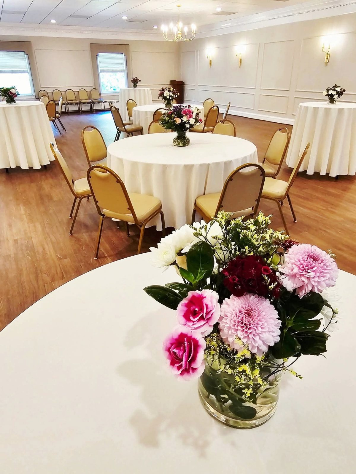 Banquet round set with white linens and fresh florals in the ballroom